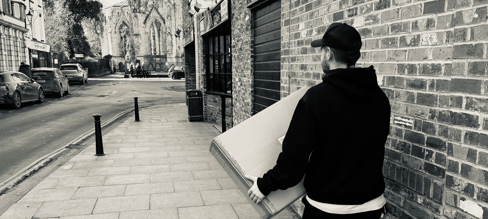 Sam Bettley carrying a wrapped painting commission to ship